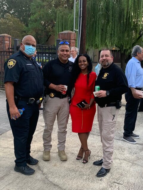 Three law enforcement officers in their uniforms with one event attendee wearing a dress